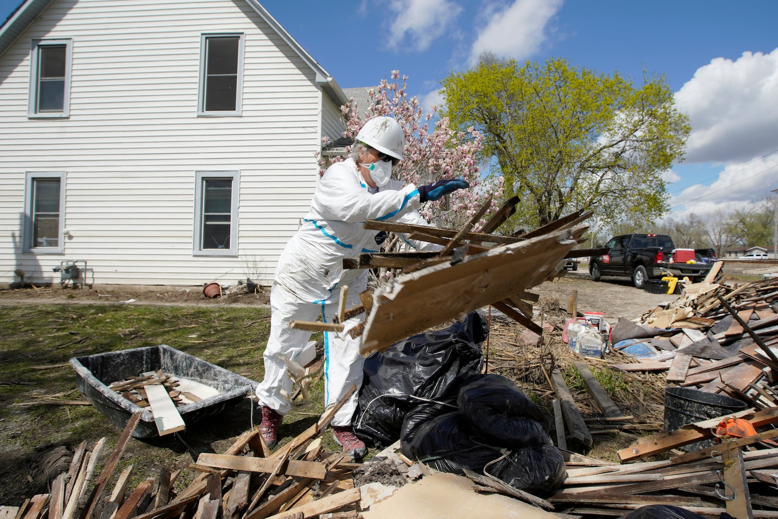 FILE - A volunteer with Team Rubicon discards flood-damaged materials from a house in Pacific Junction, Iowa, April 18, 2019. (AP Photo/Nati Harnik, File)
