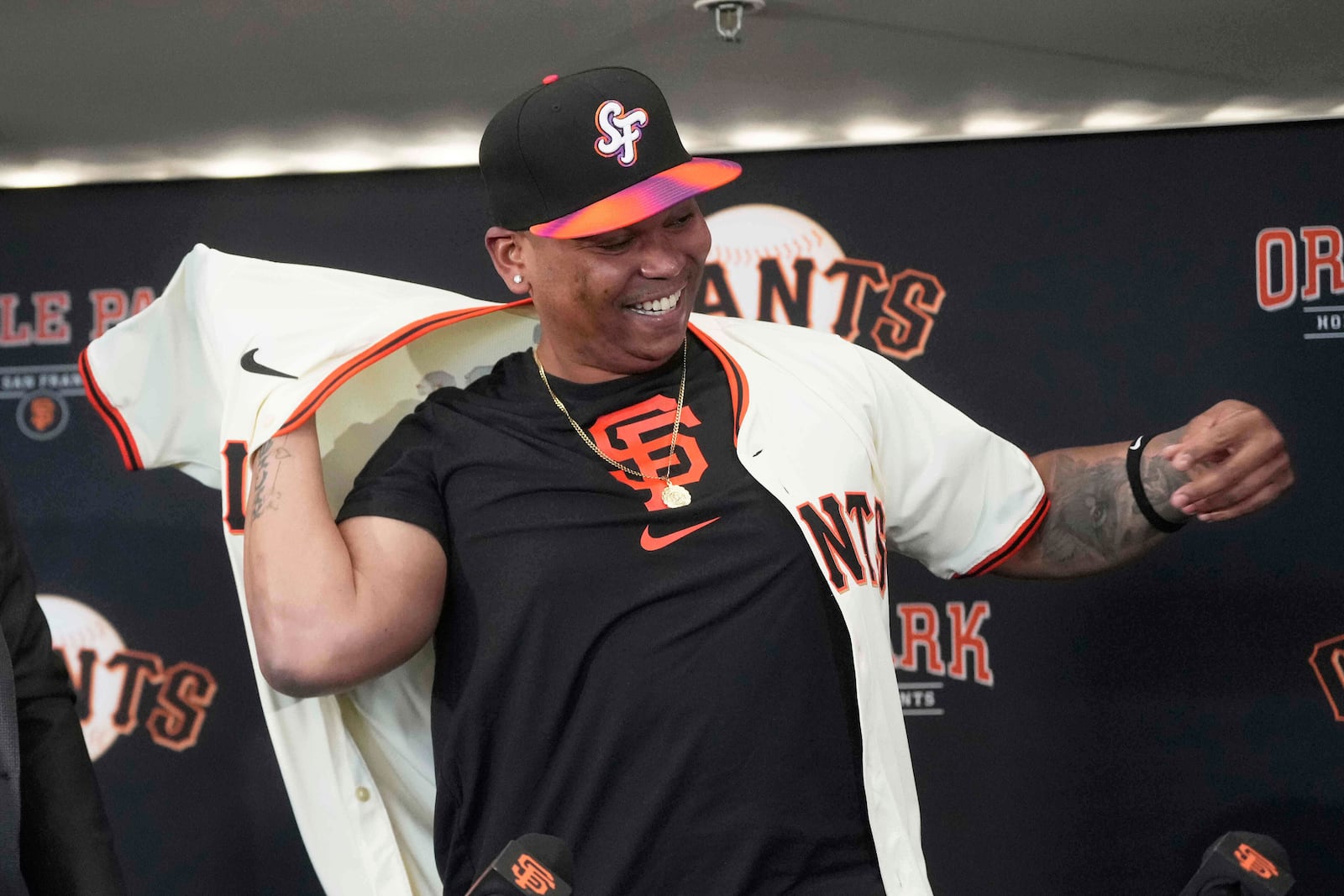 San Francisco Giants' Rafael Devers puts on a jersey at a news conference before a baseball game against the Cleveland Guardians in San Francisco, Tuesday, June 17, 2025. (AP Photo/Jeff Chiu)