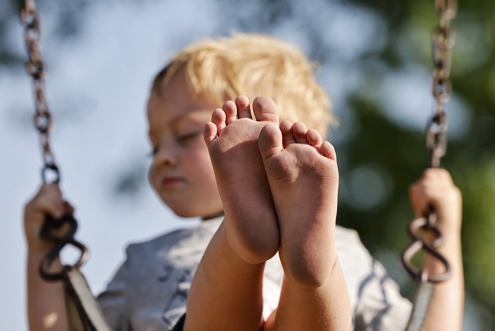 Drew Puckett, 3, plays at a park Thursday, Aug. 26, 2021 in Hanover Township. Puckett was treated by Shriner's Children's Ohio for severe burns to his feet last year after he walked through hot coals that remained after a campfire. NICK GRAHAM / STAFF