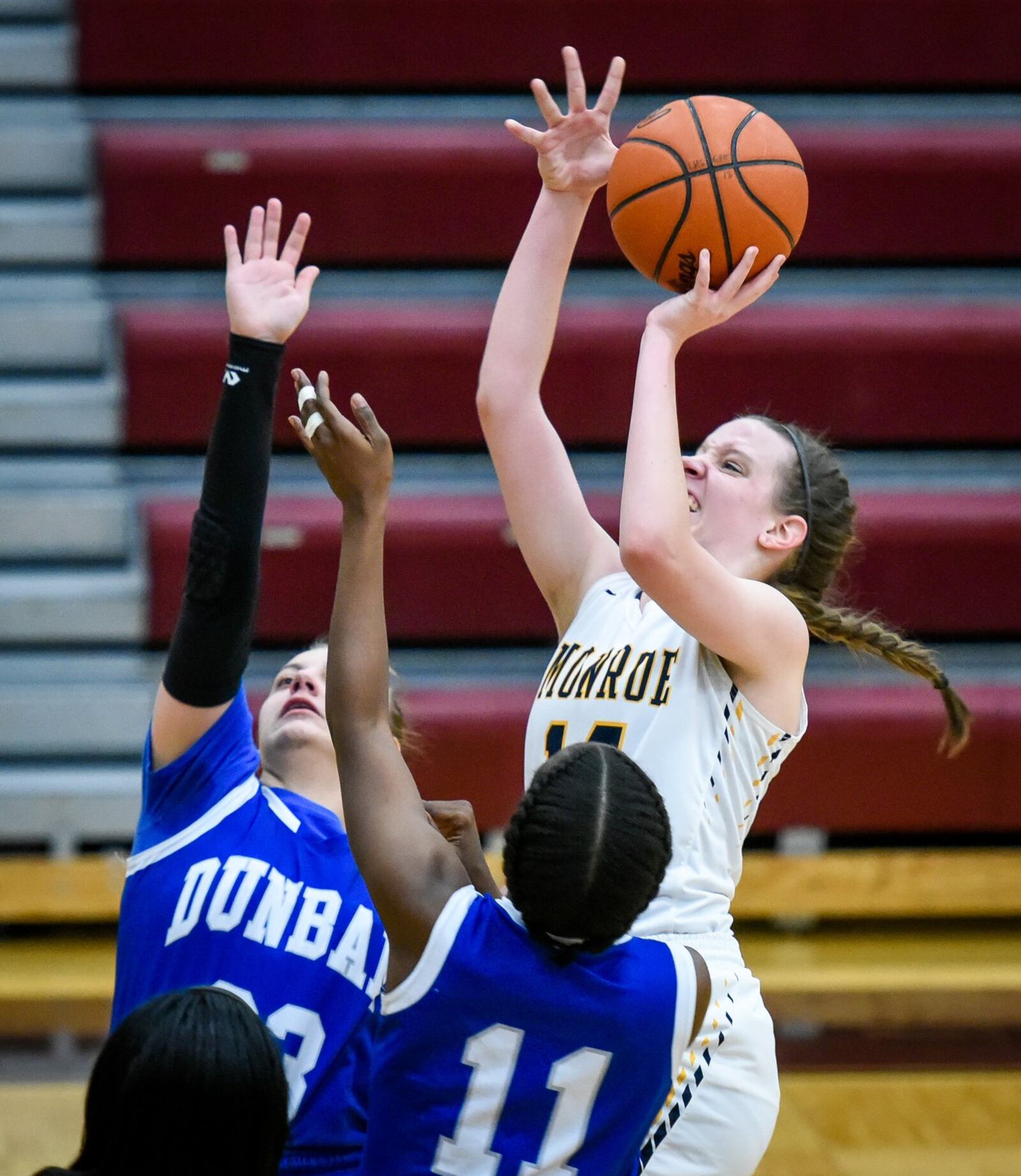 Monroe’s Sophie Sloneker goes up and over Dunbar’s Myalisa Beal (11) and Aria Cole for a shot during Thursday night’s Division II sectional game at Lebanon. NICK GRAHAM/STAFF