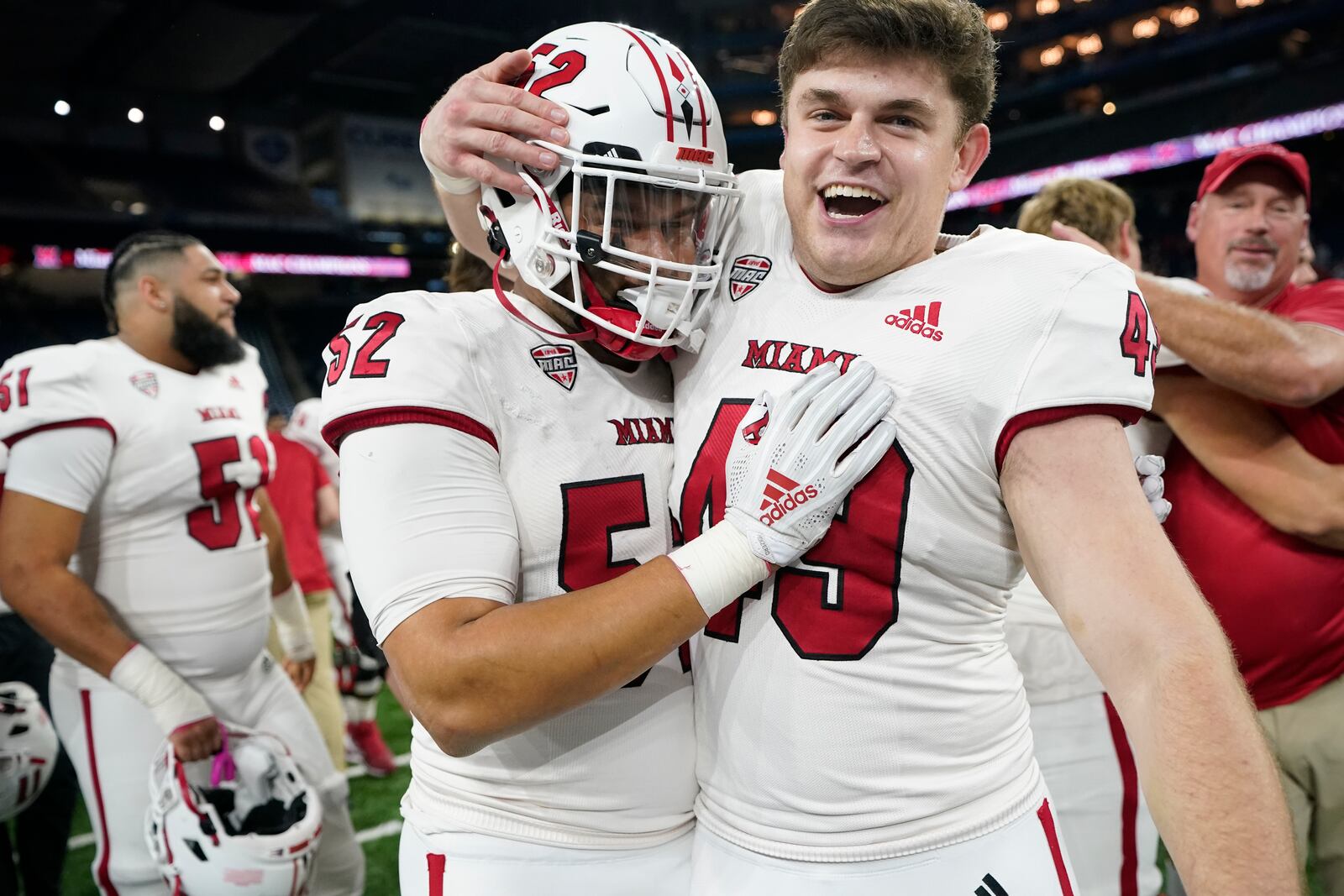 Miami (Ohio) defensive linemen Nasir Washington (52) and Jacob Snell (49) celebrate the team's 23-14 win over Toledo in a Mid-American Conference championship NCAA college football game, Saturday, Dec. 2, 2023, in Detroit. (AP Photo/Carlos Osorio)
