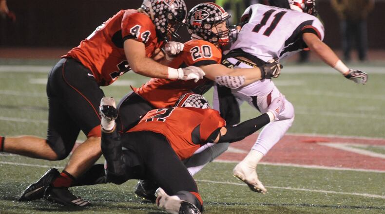 Fort Loramie’s CJ Billing (44), Max Hoying (20) and Devin Wehrman (bottom) take down McComb’s Tyler Durfey. McComb defeated Fort Loramie 28-14 in a D-VII high school football state semifinal at Wapakoneta on Saturday, Nov. 24, 2018. MARC PENDLETON / STAFF