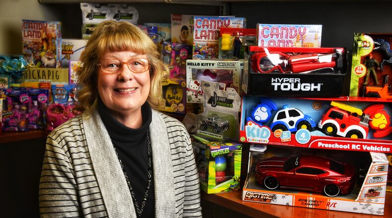 Jerri Langworthy, director of community involvement for United Way of Warren County, picks up toys collected by Centerpoint Health in Middletown Friday, Dec. 18, 2020. The toys from Centerpoint and other toys donated throughout Warren County will be donated to food pantries to distribute to families in need. NICK GRAHAM / STAFF