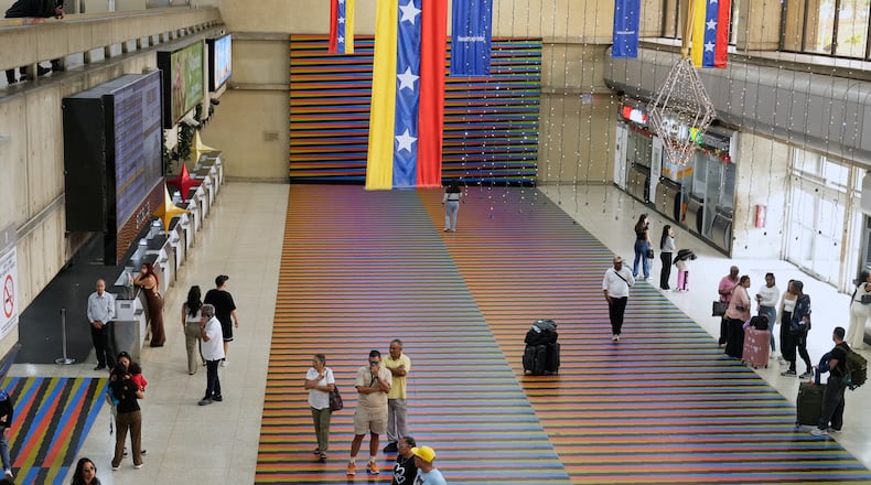 Travelers wait in the main hall of the Simon Bolivar Maiquetia International Airport in Maiquetia, Venezuela, Sunday, Nov. 23, 2025, after several international airlines canceled flights following a warning from the U.S. Federal Aviation Administration about a hazardous situation in Venezuelan airspace. (AP Photo/Ariana Cubillos)