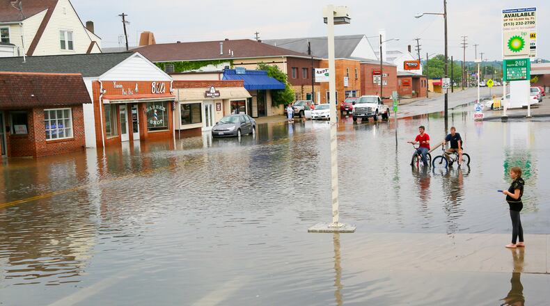 In June 2016, Hamilton city crews worked to clear drains in the flooded areas of Main Street on the west side of Hamilton after heavy rain and flash flooding. GREG LYNCH / STAFF