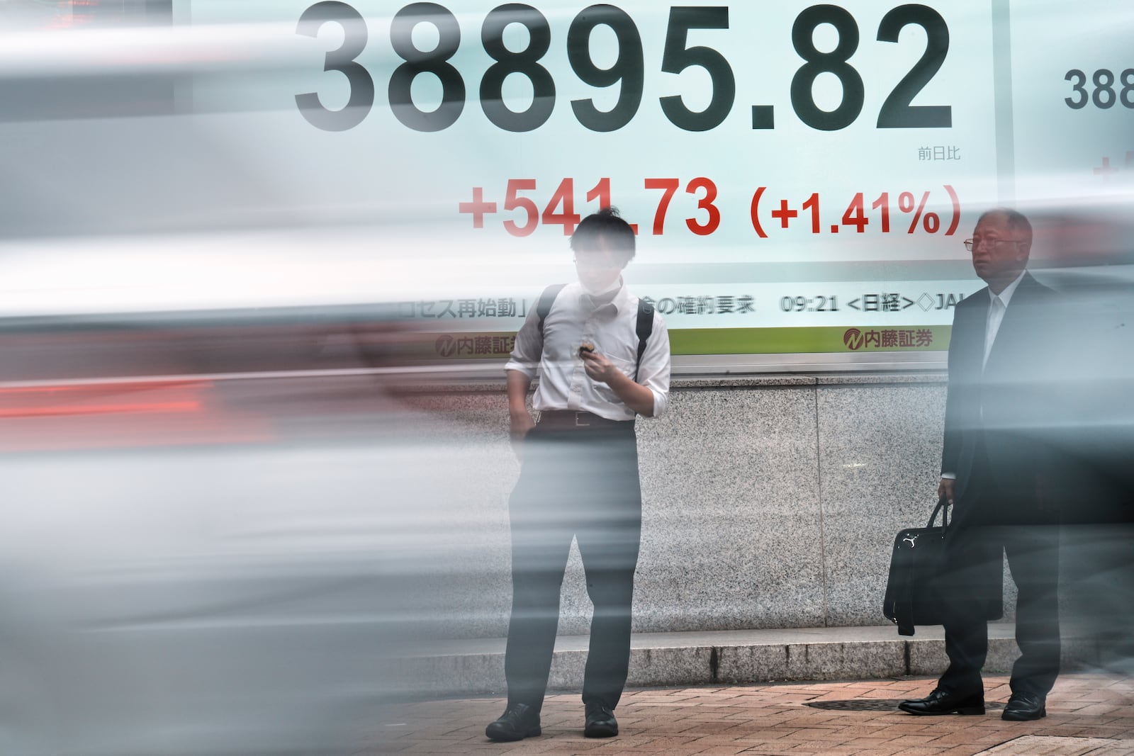 People stand in front of an electronic stock board showing Japan's Nikkei index at a securities firm Tuesday, June 24, 2025, in Tokyo. (AP Photo/Eugene Hoshiko)