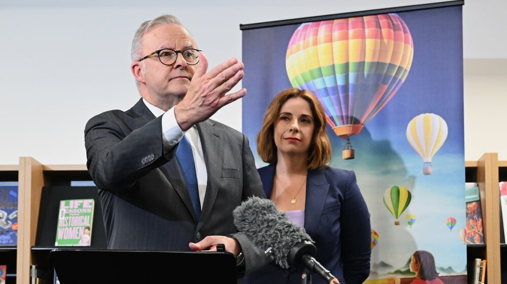 Australian Prime Minister Anthony Albanese, left, and Australian Communications Minister Anika Wells speak to the media during a visit to St John Paul II College in Canberra, Australia, on Dec. 11, 2025. (Lukas Coch/AAP Image via AP)