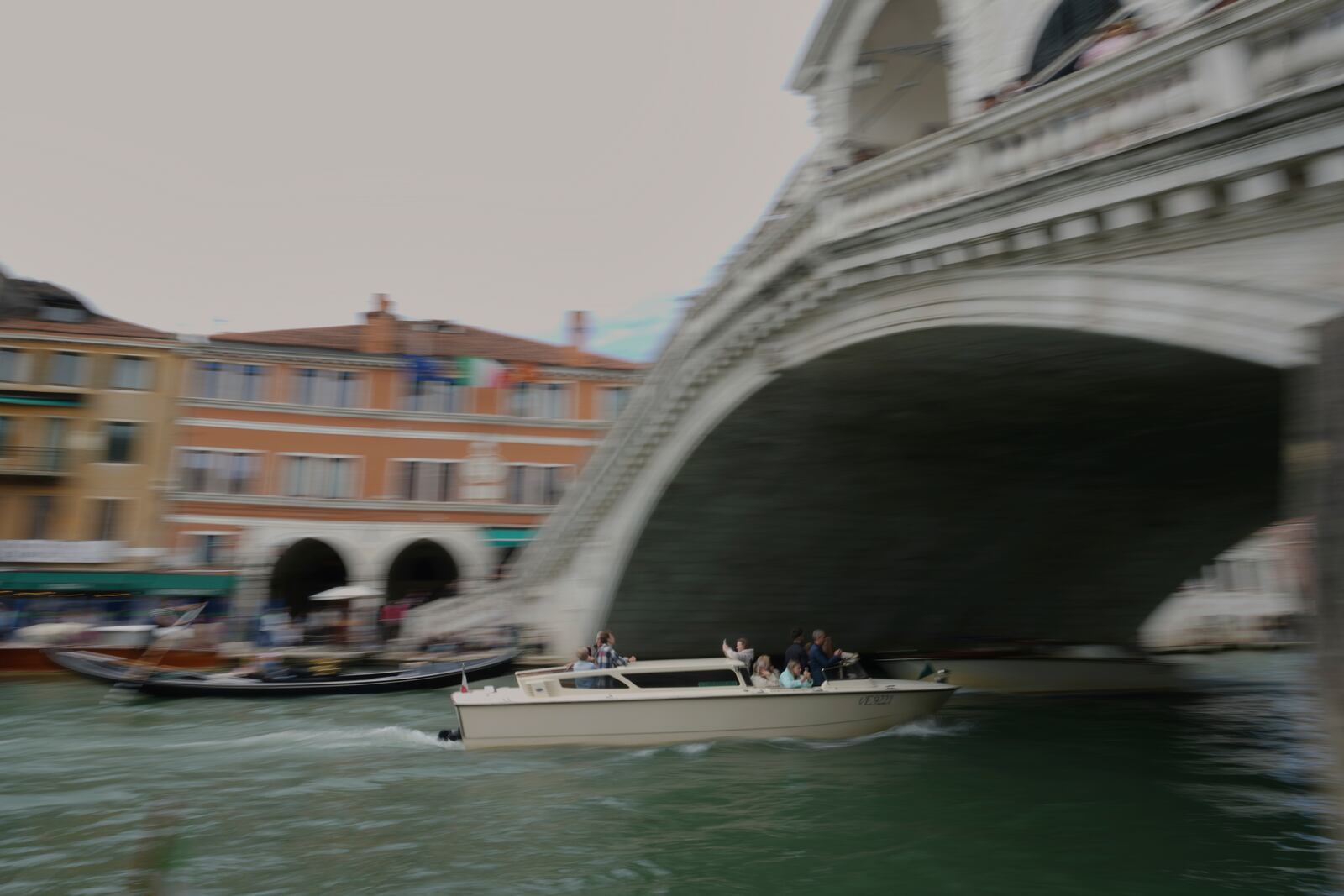 A taxi sails under the Rialto Bridge "Ponte di Rialto" in Venice, Italy, Friday, April 18, 2025, Venice on Friday launches for a second year a pilot program to charge day-trippers an entrance fee. (AP Photo/Antonio Calanni)