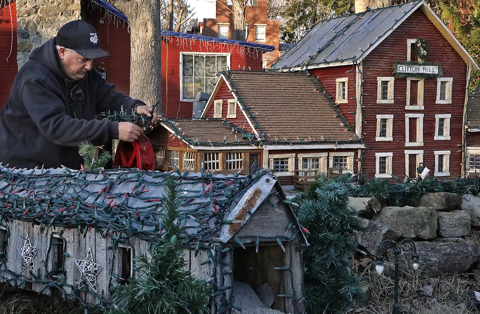 Anthony Satariano, the owner of Clifton Mill, puts lights on a miniature Clifton Mill for the 2020 display. BILL LACKEY/STAFF