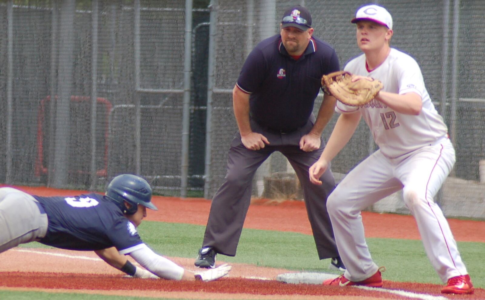 Carlisle first baseman Logan Baker waits for the throw in a pickoff attempt against Cincinnati Country Day’s Cameron Davis on Thursday during a Division III regional semifinal at the Athletes in Action complex in Xenia. CONTRIBUTED PHOTO BY JOHN CUMMINGS