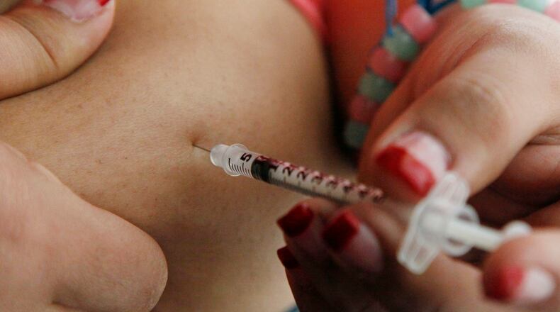 FILE - In this April 29, 2012 file photo, a woman diagnosed with diabetes gives herself an injection of insulin at her home in the Los Angeles suburb of Commerce, Calif. (AP Photo/Reed Saxon, File)