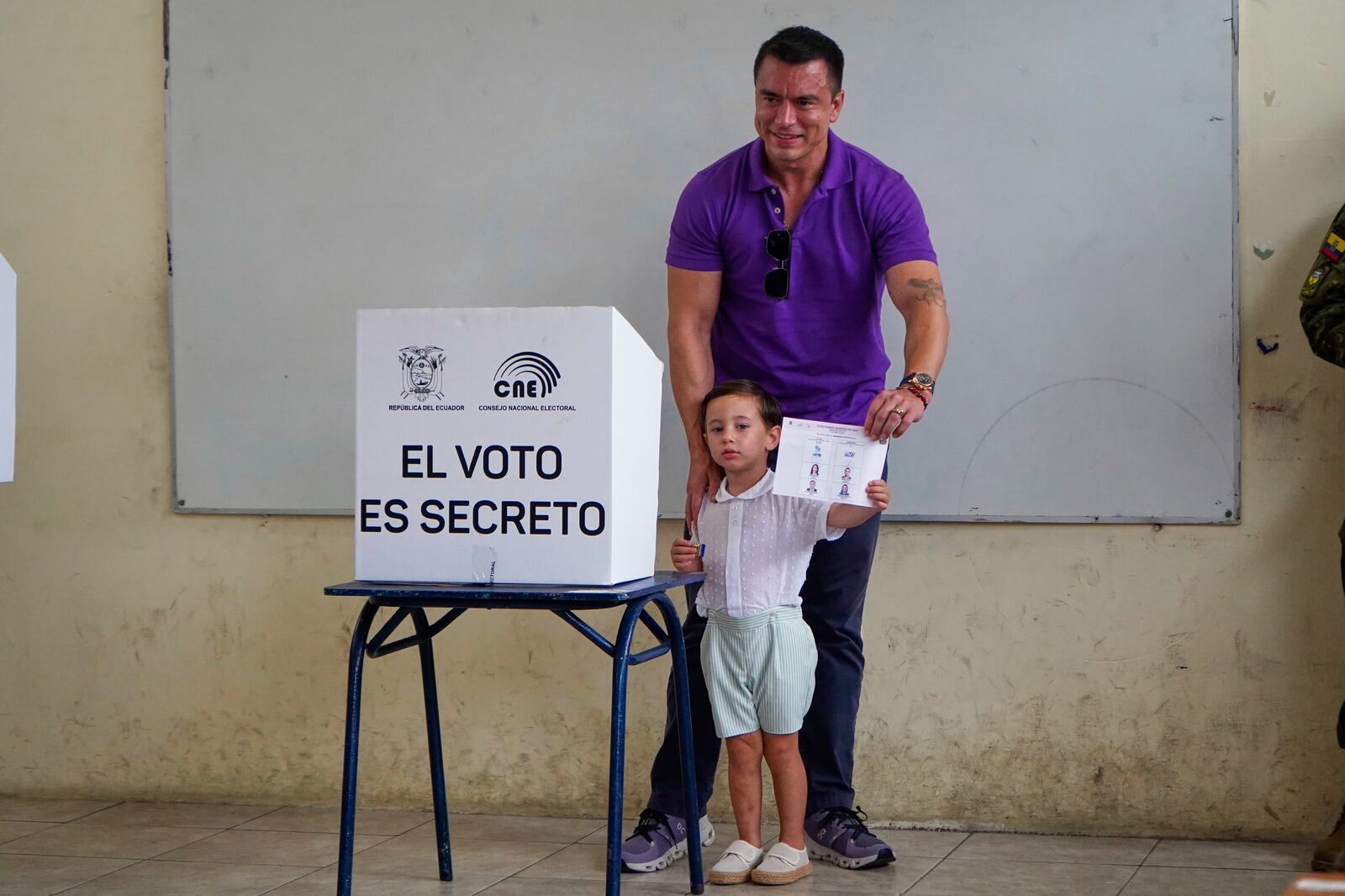 Incumbent President Daniel Noboa shows his ballot casts before voting, accompanied by his children, in the presidential election runoff in Olon, Ecuador, Sunday, April 13, 2025. (AP Photo)