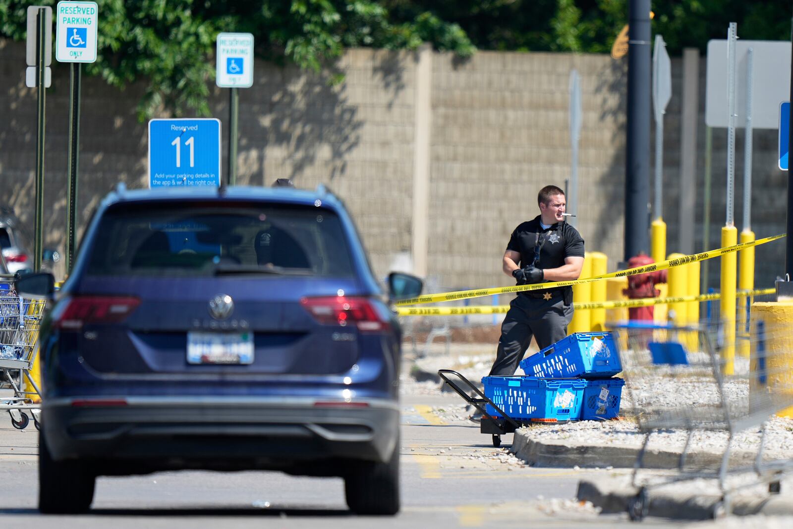 Law enforcement officers investigate outside of a Walmart, Sunday, July 27, 2025, where a multiple stabbing took place on Saturday, in Traverse City, Mich. (AP Photo/Ryan Sun)