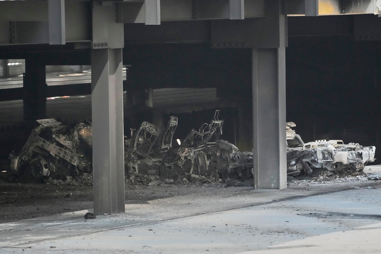 A burned vehicle is seen inside a garage that caught fire and a floor of the structure collapsed Tuesday, June 10, 2025, in Nashville, Tenn. (AP Photo/George Walker IV)