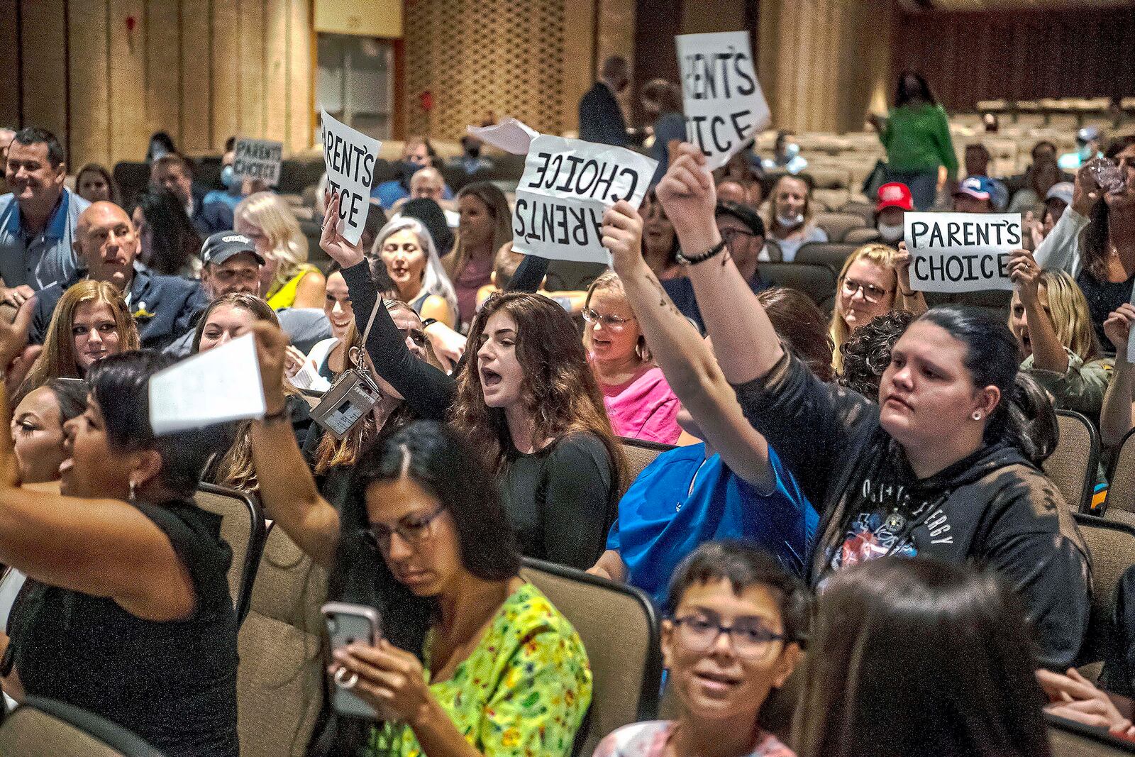 FILE - People hold signs and chant during a meeting of the North Allegheny School District school board regarding the district's mask policy, at at North Allegheny Senior High School in McCandless, Pa., Aug. 25, 2021. School board candidates opposing mask mandates and lessons about racism in U.S. history won in red states and some politically divided districts but often came up short in their bids to shape policy for school districts over the newest culture war issue. (Alexandra Wimley/Pittsburgh Post-Gazette via AP, File)