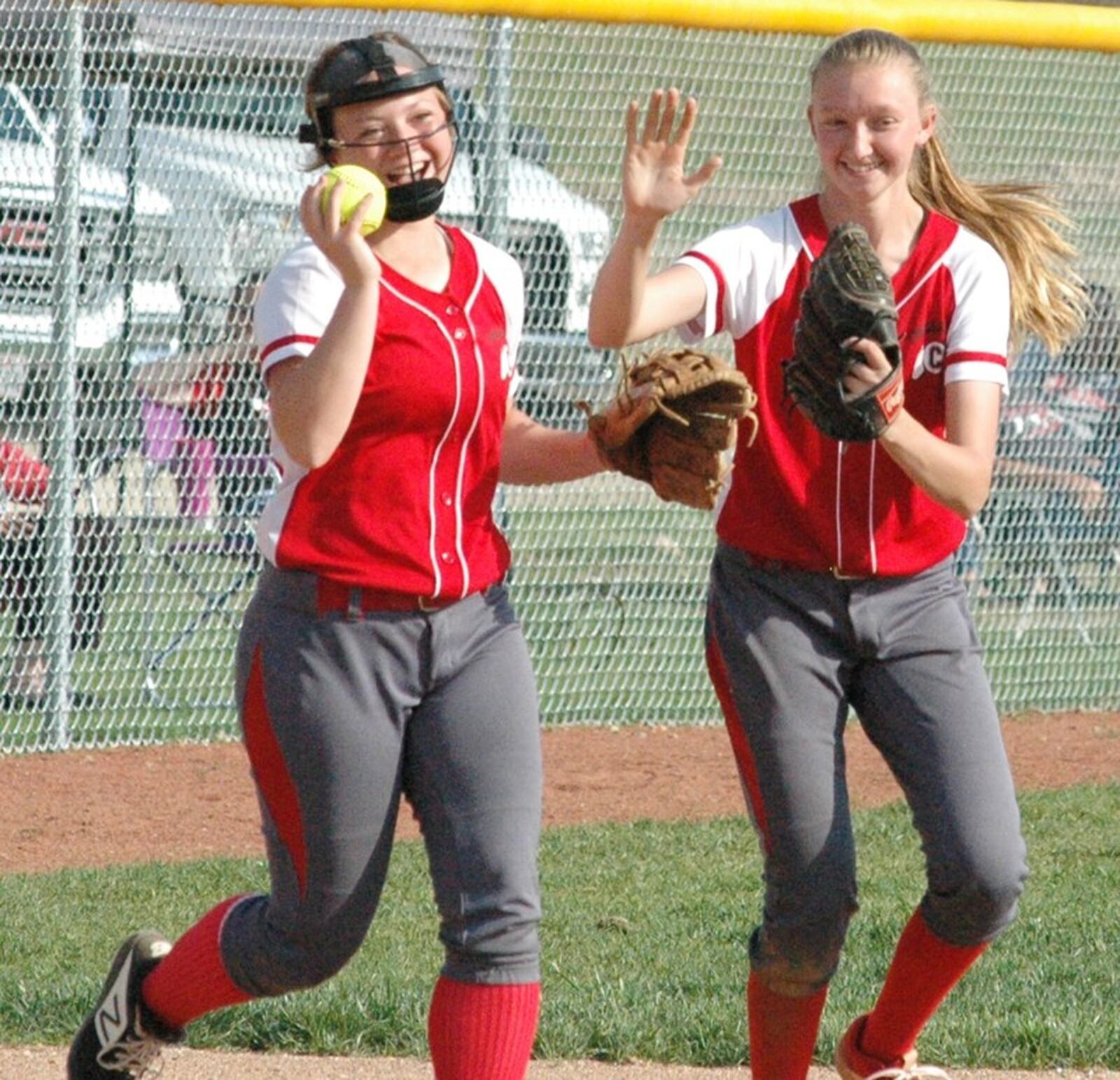 Carlisle High School third baseman Kaylee Lawson (left) and shortstop Caitlyn Stewart share a light moment after Lawson made a catch May 8 during a Division III sectional softball game against visiting Indian Lake. Carlisle won 2-1. RICK CASSANO/STAFF