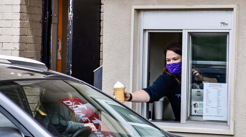 Samantha Maney takes orders Tuesday at the drive through at Triple Moon Coffee Company. Triple Moon closed due to the coronavirus pandemic and has opened up for service at the drive thru toward the rear of the building. The Middletown Community Foundation awarded $20,000 to the Downtown Middletown Inc. for rent and utility assistance to 36 struggling businesses.. NICK GRAHAM/STAFF