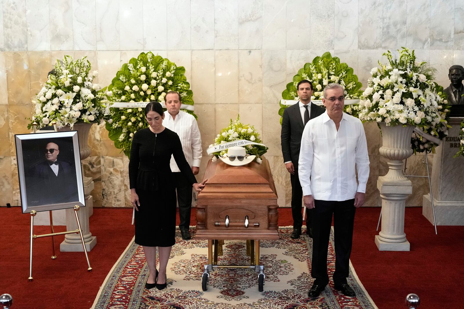 Dominican Republic President Luis Abinader, front right ands his wife Raquel Arbaje Soni, front left, attend the wake of Dominican singer Rubby Perez who died in the roof collapse at the Jet Set nightclub during his merengue concert, at the Eduardo Brito National Theater in Santo Domingo, Dominican Republic, Thursday, April 10, 2025. (AP Photo/Matias Delacroix)