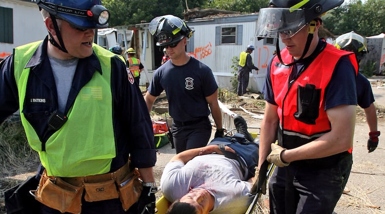 Butler County Emergency Management Agency workers rescue a survivor during a mock tornado drill in 2010. STAFF FILE/2010
