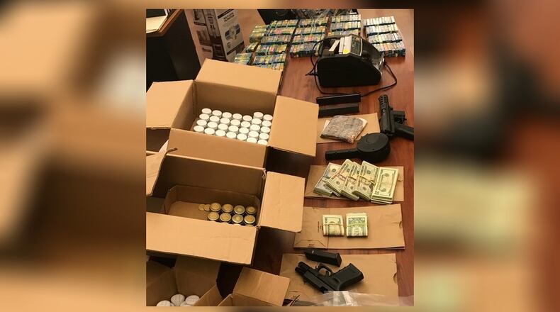 Drugs, guns and cash taken from a New Miami residence Monday by the Butler County Sheriff’s Office. SUBMITTED