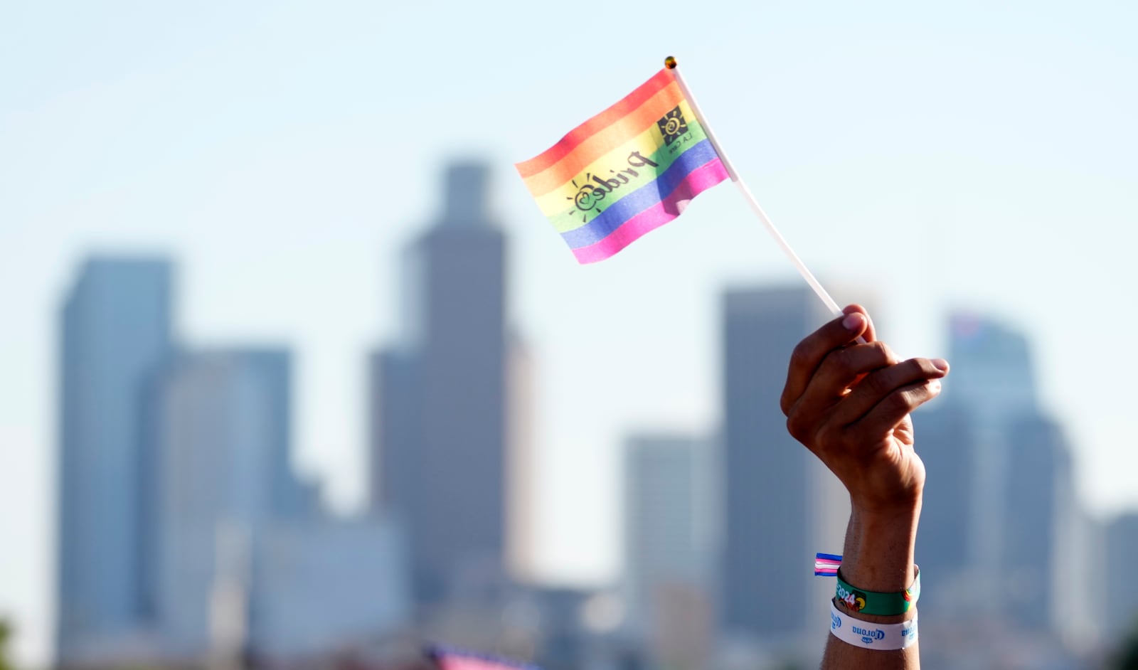 A pride flag is waved against the downtown Los Angeles skyline during the LA Pride in the Park festival at Los Angeles State Historic Park, June 8, 2024, in Los Angeles. (AP Photo/Chris Pizzello)