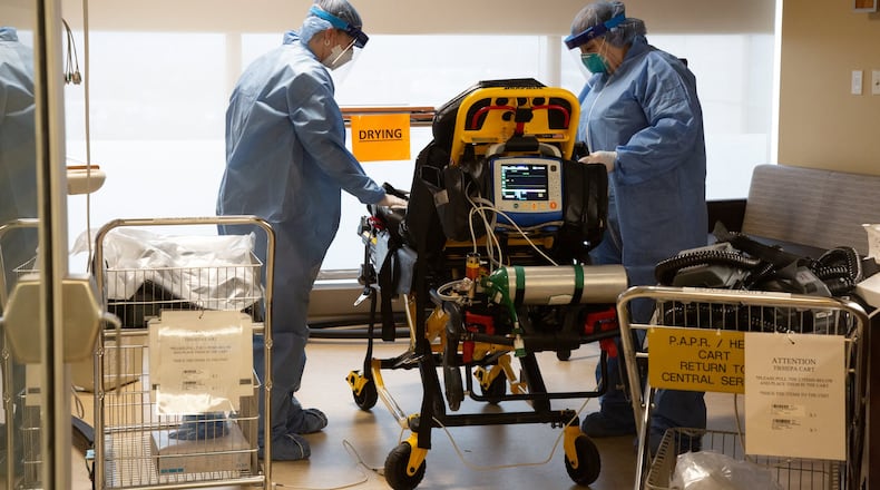 Jessica Oakley and Carol Mousa, flight nurses for Premier Health’s CareFlight Air and Mobile Services, are in the designated decontamination area on the COVID-19 unit, cleaning equipment and a MICU stretcher that were used for a suspected COVID-19 transport.
