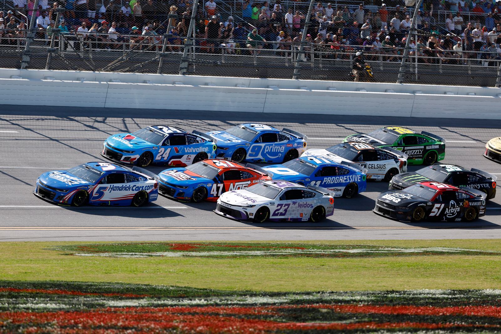 Kyle Larson (5) leads the pack to win the first stage during a NASCAR Cup Series auto race at Talladega Superspeedway, Sunday, April 27, 2025, in Talladega, Ala. (AP Photo/Butch Dill)