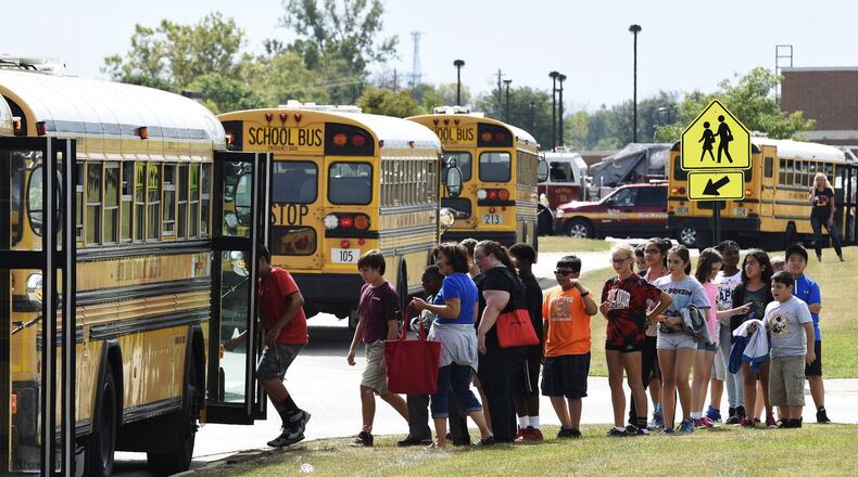 Endeavor Elementary School students line up to get on a bus to be transported to Lakota West Freshman School after a bomb threat was called in forcing the school to be evacuated Friday, Sept 25. A bomb sniffing dog from the Miami University Police department was called to the scene and searched and cleared the building. NICK GRAHAM/STAFF