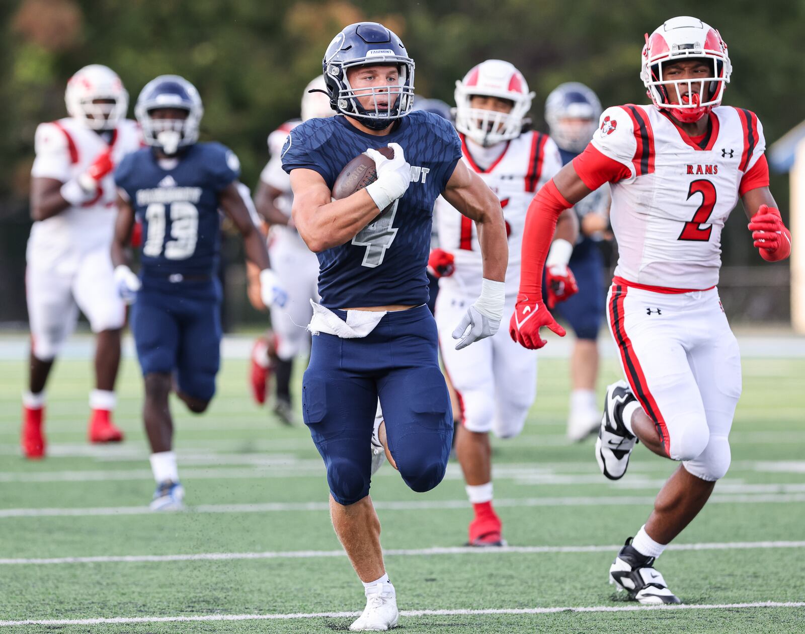 Fairmont junior running back Logan Doty runs as Trotwood-Madison's Darius Dennis pursues during a nonconference game on Friday, Aug. 29 at Roush Stadium in Kettering. BRYANT BILLING / STAFF