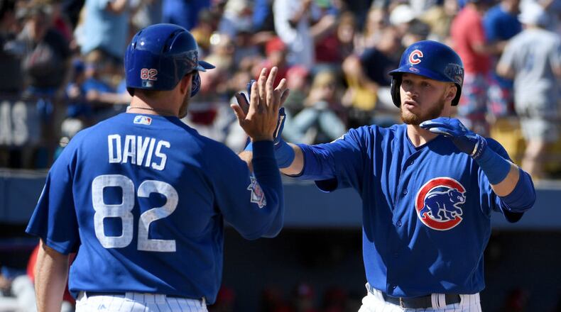 LAS VEGAS, NV - MARCH 25: Ian Happ (R) #86 of the Chicago Cubs high-fives teammates including Taylor Davis #82 after Happ hit a three-run home run in the fifth inning against the Cincinnati Reds during their exhibition game at Cashman Field on March 25, 2017 in Las Vegas, Nevada. The Cubs won 11-7. (Photo by Ethan Miller/Getty Images)
