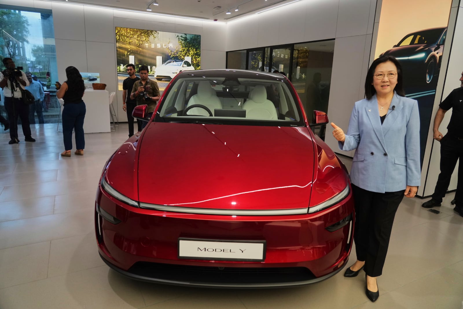 Tesla South East Asia director Isabelle Fan poses in front of Tesla Model Y car at the newly opened India's first Tesla showroom in Mumbai, India, Tuesday, July 15, 2025. (AP Photo/Rafiq Maqbool)