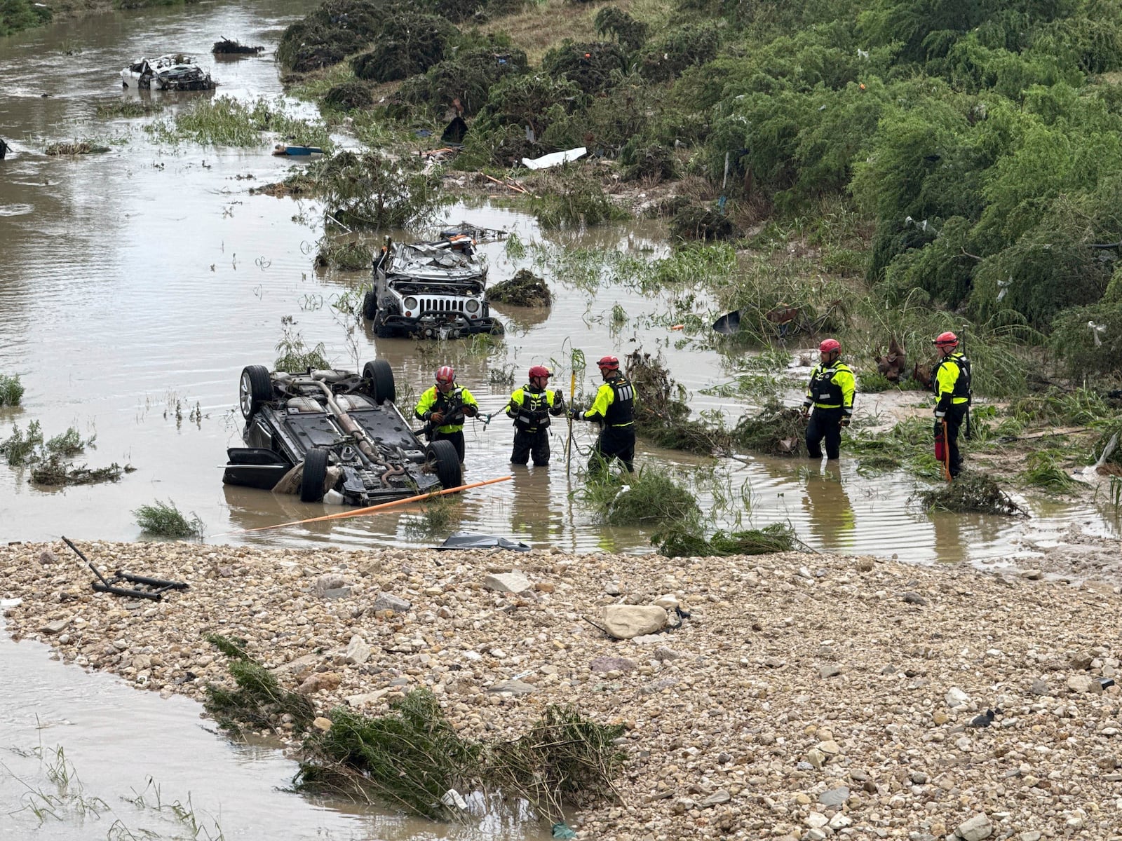 Authorities respond after vehicles were swept away by floodwaters in San Antonio, Tx., on Thursday, June 12, 2025. (AP Photo/Lekan Oyekanmi)
