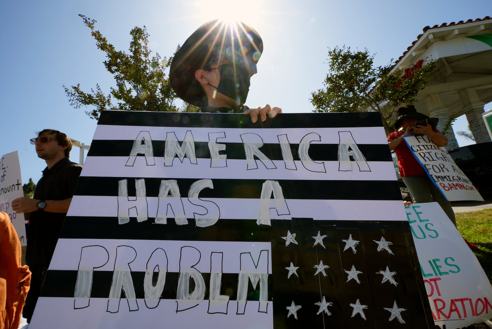 Protesters hold signs and chant slogans during a protest against the Trump Administration's immigration policies in Paramount, Calif. on Tuesday, June 17, 2025. (AP Photo/Damian Dovarganes)