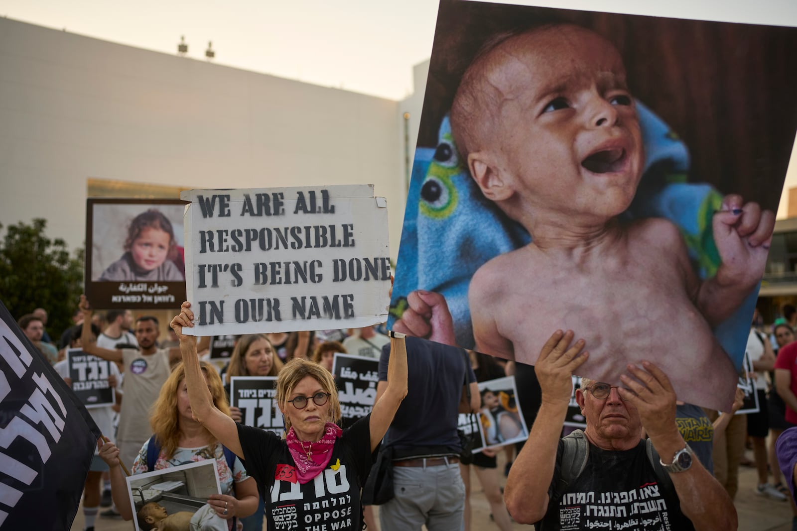 Israeli activists take part in a protest against the war in the Gaza Strip, Israel's measures regarding food distribution and the forced displacement of Palestinians, in Tel Aviv, Israel, Tuesday, July 22, 2025. (AP Photo/Ohad Zwigenberg)