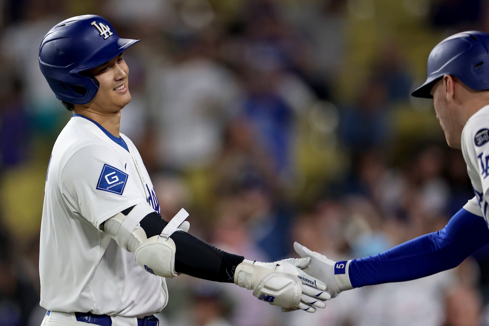 Los Angeles Dodgers designated hitter Shohei Ohtani is congratulated by teammate Freddie Freeman after hitting a home run during the ninth inning of a baseball game against the Minnesota Twins Tuesday, July 22, 2025, in Los Angeles. (AP Photo/Eric Thayer)