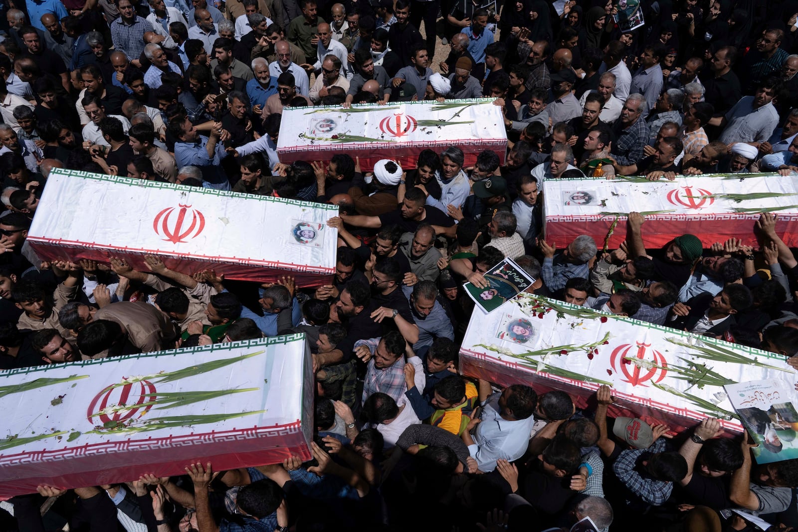 Mourners carry the flag-draped coffins of five men, whose names were not immediately available, reportedly killed in Israeli strikes, during their funeral in the city of Khorramabad, Iran, Monday, June 16, 2025. (AP Photo/Aziz Babanezhad/Tasnim News Agency)