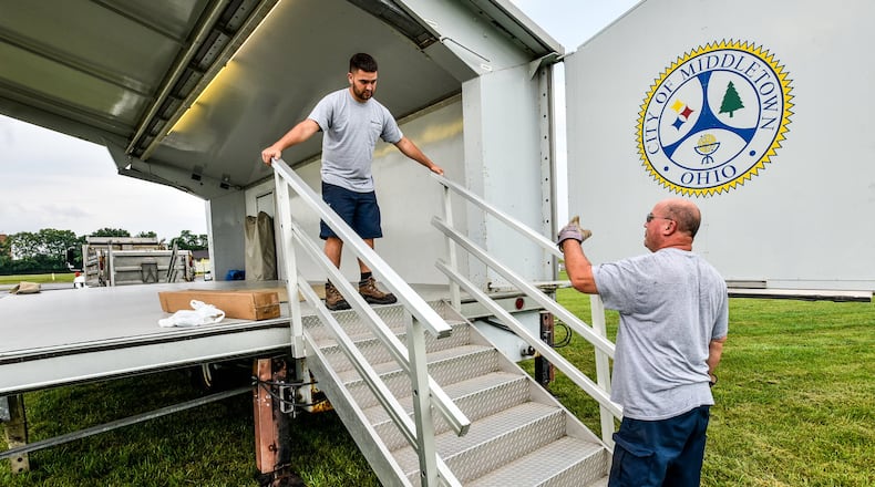 Ryan Roberts, left, and Robin Shope set up the stage in preparation for the Broad Street Blast Wednesday, July 3 at Smith Park in Middletown. NICK GRAHAM/STAFF