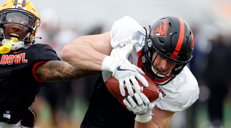 American tight end Luke Musgrave of Oregon State catches a pass over American defensive back Jay Ward of LSU during practice for the Senior Bowl NCAA college football game, Thursday, Feb. 2, 2023, in Mobile, Ala.. (AP Photo/Butch Dill)
