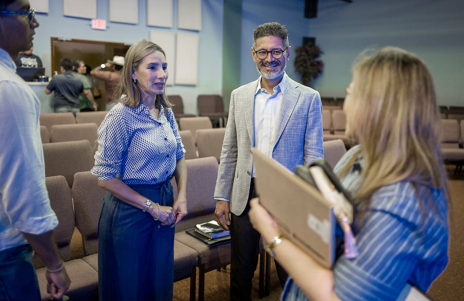 José Luis Orozco, a pastor from Nicaragua, speaks to Oasis Church, senior pastor, Maria Flores, right, following a sermon by Orozco, as son, Josias, and wife, Ruth, look on, in Taylor, Texas, June 15, 2025. (AP Photo/Rodolfo Gonzalez)
