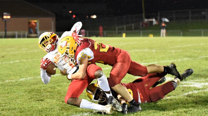 Fenwick’s Logan Miller (26) and Carter Earls bring down Purcell Marian’s Da’Montay Everett on Friday night at Krusling Field in Middletown Fenwick won 31-14. CONTRIBUTED PHOTO BY ANGIE MOHRHAUS
