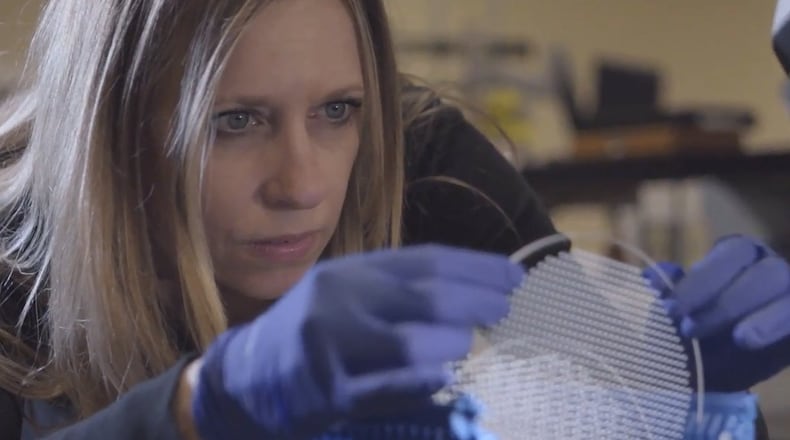 In this file photo, Bullen Ultrasonics employee Robin Brown inspects a MEMS glass wafer, a key component in the production of ventilators.