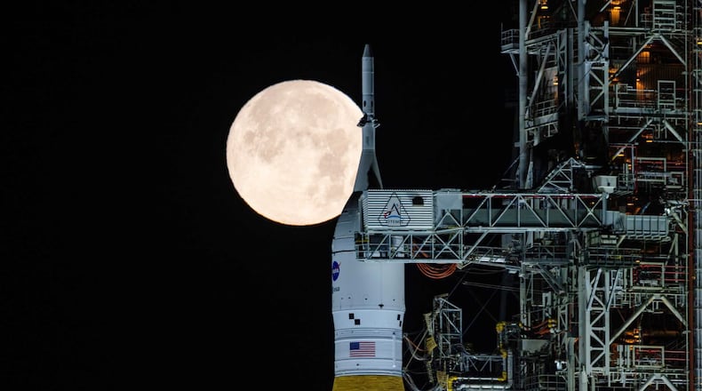 A full moon is seen shining over NASA’s SLS (Space Launch System) and Orion spacecraft, atop the mobile launcher in the early hours of Sunday, Feb. 1, 2026, at NASA’s Kennedy Space Center in Florida. (Sam Lott/NASA via AP)