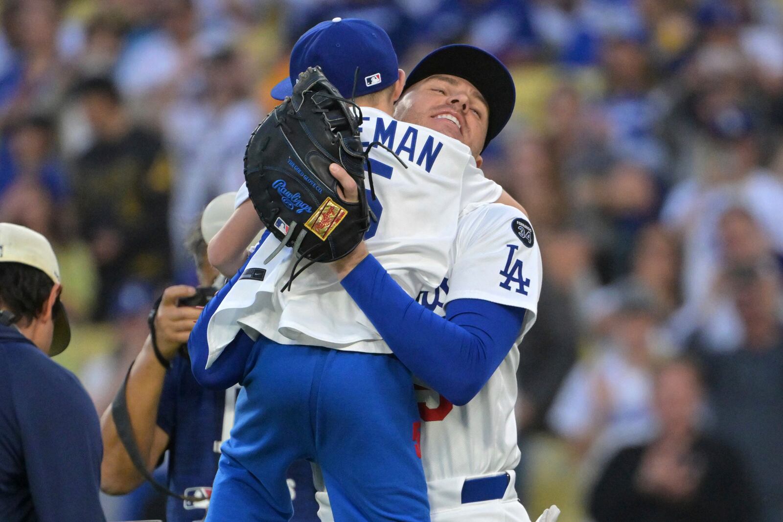 Los Angeles Dodgers first baseman Freddie Freeman hugs his 9-year-old son Charlie after he threw out the first pitch before a baseball game against the Chicago Cubs, Friday, April 11, 2025, in Los Angeles. (AP Photo/Jayne Kamin-Oncea)