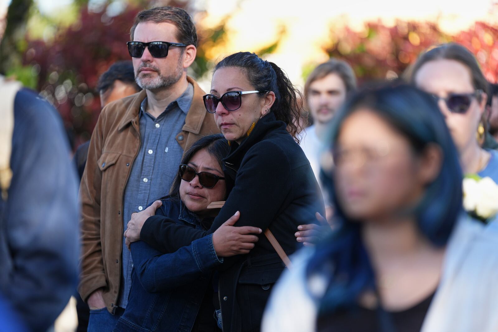 Two women embrace at a memorial after a vehicle drove into a crowd during a Filipino heritage festival in Vancouver, British Columbia, Sunday, April 27, 2025. (AP Photo/Lindsey Wasson)