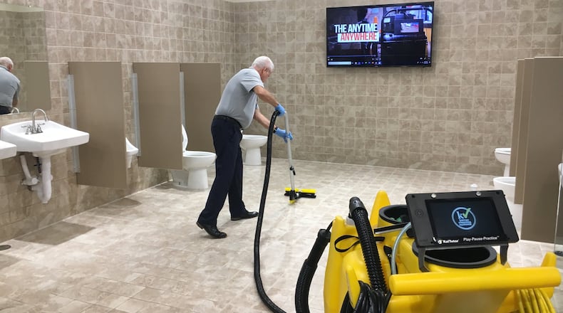Leon Fields, business development manager for Hamilton-based Kaivac Cleaning Systems, demonstrates to a group how quickly and effectively one of the company’s machines can work. MIKE RUTLEDGE/STAFF