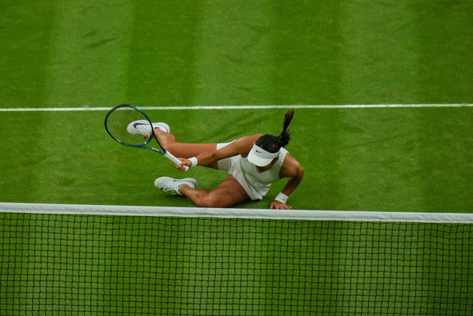Emma Raducanu of Britain slips and falls attempting to return to Aryna Sabalenka of Belarus during a third round women's singles match at the Wimbledon Tennis Championships in London, Friday, July 4, 2025. (AP Photo/Joanna Chan)