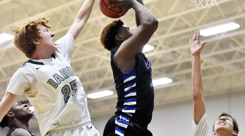 Badin’s Zach Switzer blocks a shot by Cincinnati Christian’s Wayne Lavender during their game Dec. 1 at Mulcahey Gym in Hamilton. NICK GRAHAM/STAFF