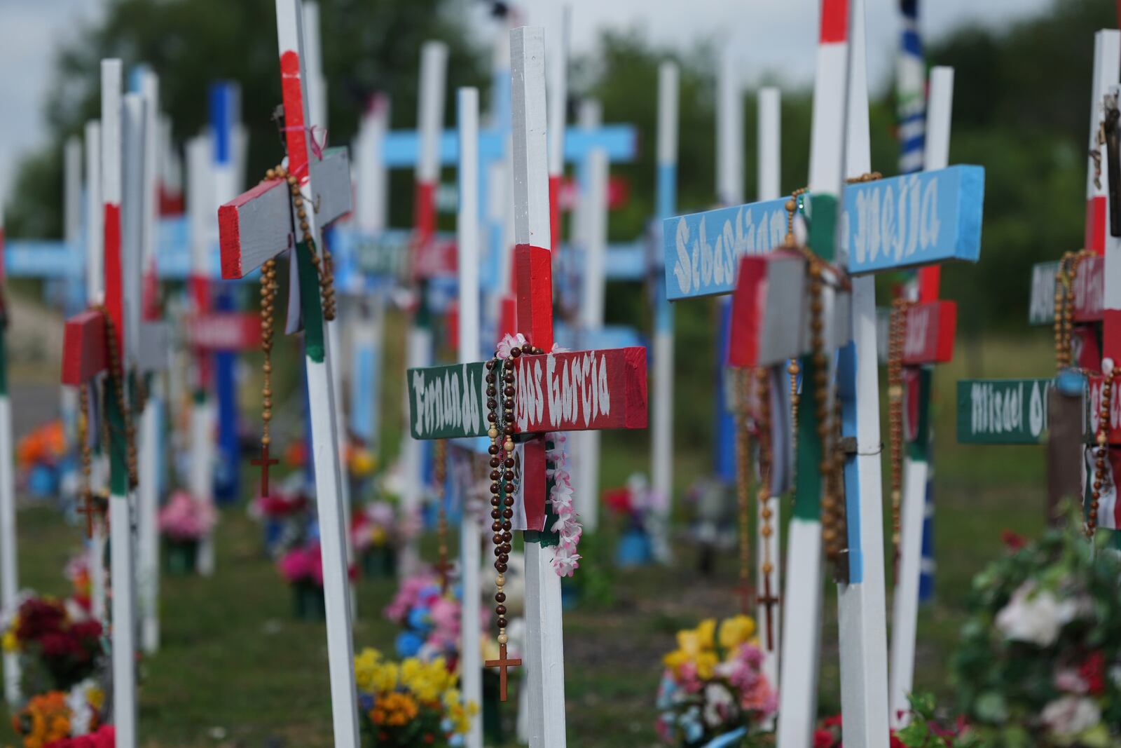 Crosses stand at a memorial honoring the victims and survivors of a human smuggling tragedy where dozens of migrants were found in an airless tractor-trailer rig two years ago, in San Antonio, Friday, June 27, 2025. (AP Photo/Eric Gay)