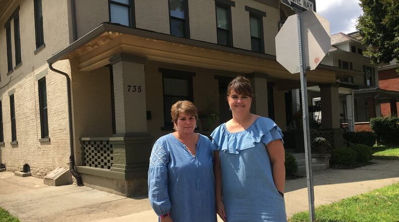 Missy Mick, director of project development, and Lori DiStaola, executive director of Neighborhood Housing Services of Hamilton, stand in front of a three-apartment building their non-profit organization operates on Campbell Avenue that helps people and families avoid, or transition from, homelessness. The apartments on Tuesday will be named after a longtime organization advocate, the late Louis R. Armstead. MIKE RUTLEDGE/STAFF