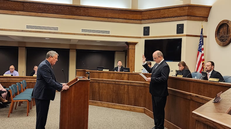 K. Philip Callahan, left, Monroe's law director, swears in Larry Lester as city manager during a recent City Council meeting. SUBMITTED PHOTO